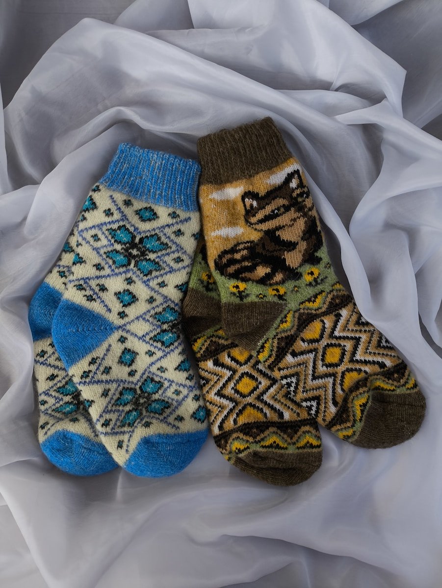 A group of three socks laying on top of a white sheet