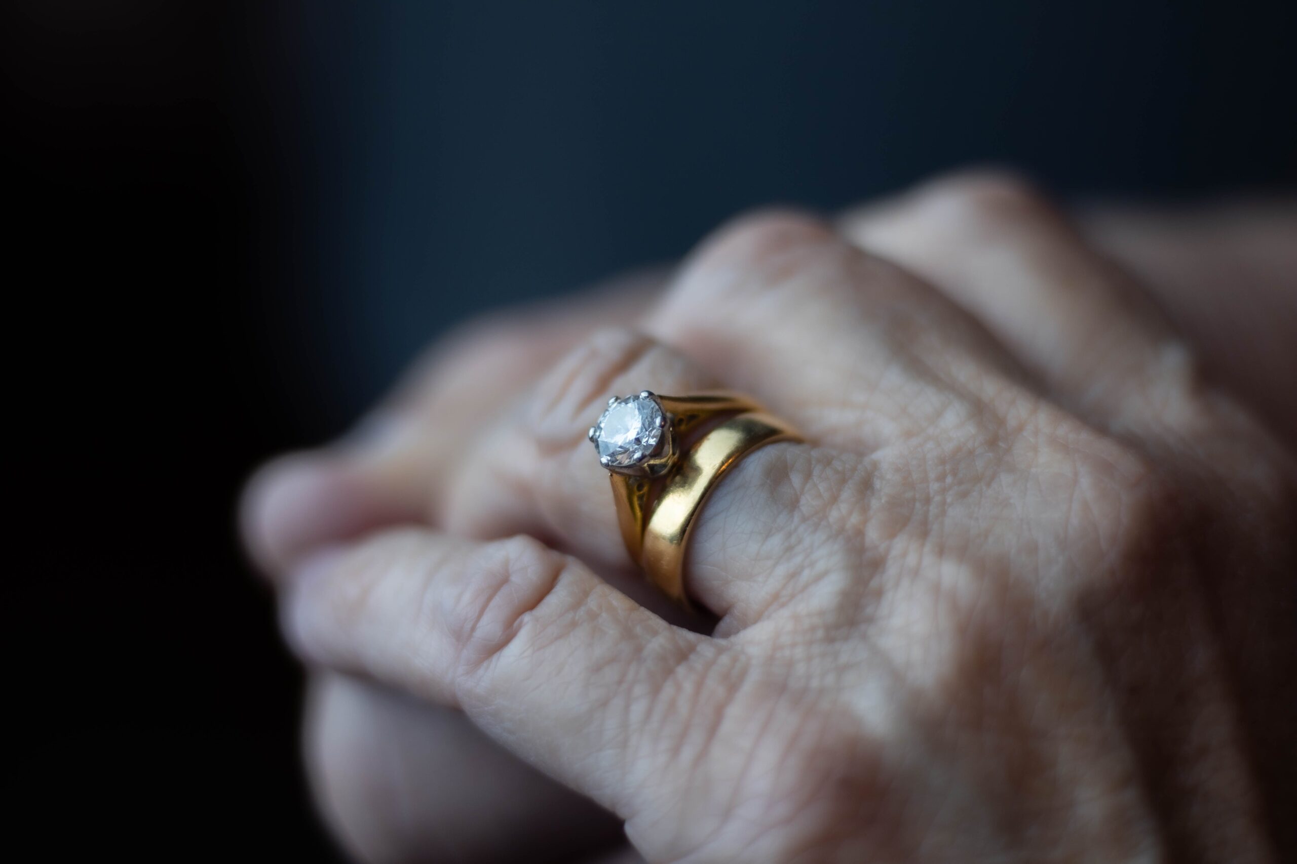 Close-up of an elegant gold ring with a diamond on a hand, showcasing luxury and sophistication.